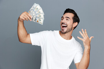 Joyful man celebrating success, holding cash in hands, smiling broadly with excitement. Isolated on...