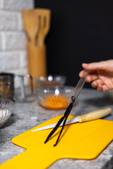 Woman hands pulling out vanilla beans from a protection glass.
