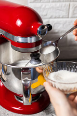 Sugar is poured into the bowl of a planetary mixer with beaten eggs. Cookie recipe. 
