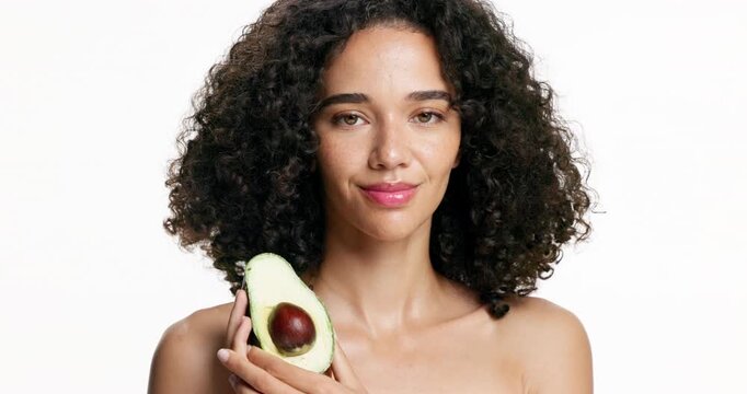 Woman, face and beauty with avocado in studio for skincare or antioxidant on a white background. Portrait, female person or model with natural organic fruit for healthy skin or anti aging treatment