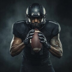 American football player in black posing gripping football with both hands