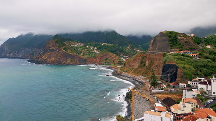 Coastal town stretching hills covered greenery aerial view. Beautiful settlement
