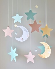 Delightful paper mobile featuring pastel moons and stars suspended against a soft background, ideal for nursery decor, whimsical crafts, or celestialthemed designs, adding a touch of dreamy elegance