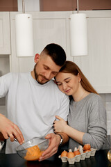 Couple Enjoys Cooking Together in a Modern Kitchen While Mixing Batter for a Delicious Dessert in the Afternoon Light