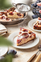 Homemade The New York Times plum cake. Slice of autumn fruit pie in a plate on beige textured background. Home cooking, recipe