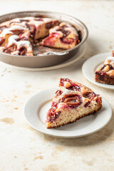 Homemade The New York Times plum cake. Sliced summer or autumn fruit pie on beige textured background. Home cooking, recipe