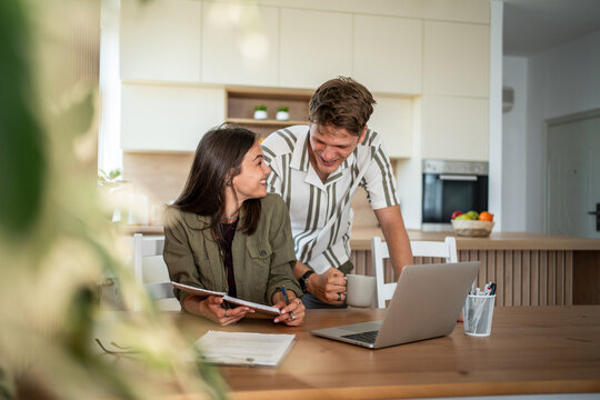 Young couple planning finances together at home kitchen