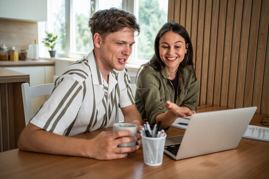 Happy couple collaborating on laptop showing teamwork