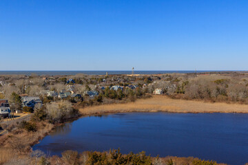 Beautiful seaside view showcasing coastal houses and a serene lake under a clear blue sky in a peaceful community