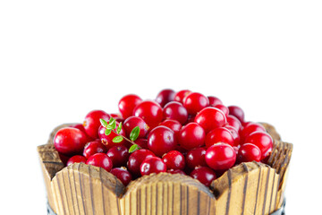 Cranberries in a wooden tub isolated on a white background.
