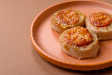Round fish or chicken cutlets baked with tomato and cheese. Fish cutlets