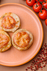 Round fish or chicken cutlets baked with tomato and cheese. Fish cutlets