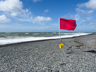 Red flag warning on beach during high wind and surf weather conditions
