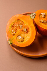Half a raw pumpkin, a ripe orange colored butternut squash. Raw pumpkin