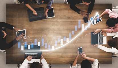 A diverse team of professionals collaborates in a modern workspace, analyzing growth trends using...