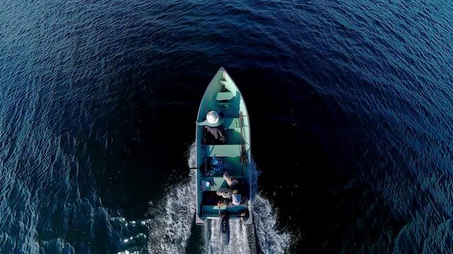 Man driving bass boat while woman seating at the front. Power sport, outboard fishing boat, with two people. Man and woman boating during fishing on the small v-hull boat.