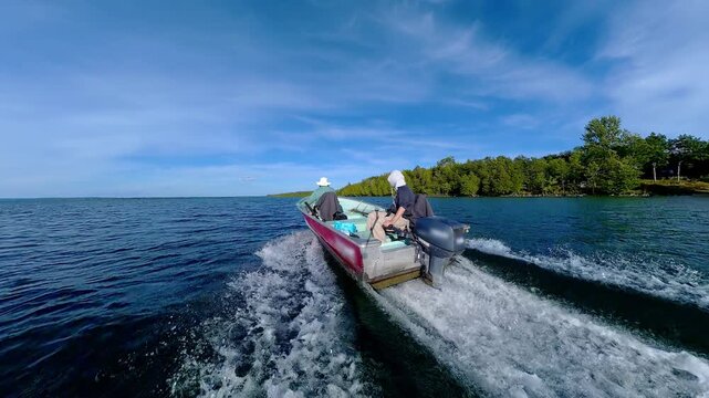 Fishermen on vacation, boating in lake Manitou, Manitoulin Island, Ontario, Canada. End of fishing game tournament. Water sport at fall. Power sport fishing and watersport.