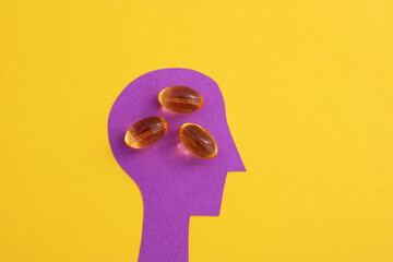 Person taking multivitamin pills, silhouette of head