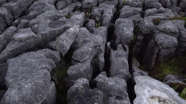 Panning from the ground of eroded rocks to the skyline of Malham Cove. 