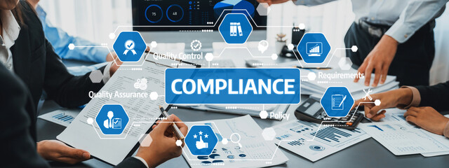 A diverse team discusses compliance and quality assurance in a modern office setting. They use...