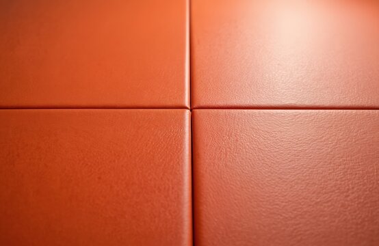 Close-up orange martial arts mat surface texture. Interlocking panels create a grid pattern on the floor. Dojo flooring for combat sports training and practice. - Powered by Adobe