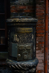 A vintage, dark cast iron mailbox with the word 