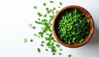 Overhead close up view shows chopped chives in wooden bowl on white surface. Fresh green herb ingredient for cooking receipe, flavorful seasoning for culinary art, tasty natural organic diet.