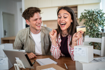 Young couple successfully completing online purchase with credit card