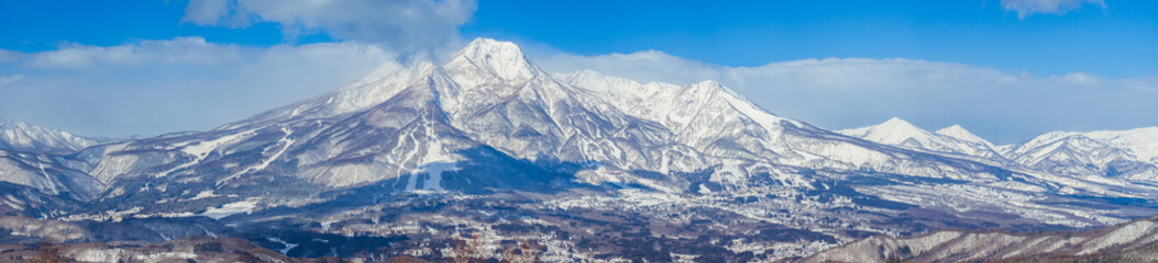 A detailed winter landscape of the snow-covered Myoko mountain range and its surrounding ski resorts in winter (viewed from Madarao, Nagano, Japan)