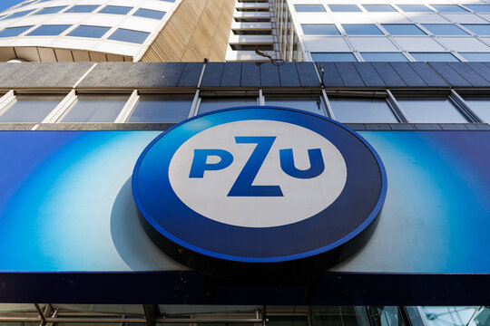 Warsaw, Poland - October 4, 2025: PZU logo sign on the facade of a modern office building in Warsaw, showing the emblem of the Polish insurance company against a blue background.