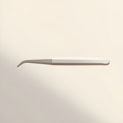 A single dental tool, a scaler or probe, lies horizontally against a plain, light background with a soft shadow.