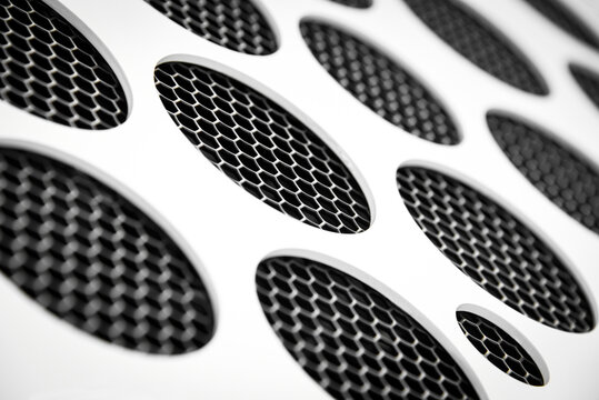 Abstract background of a white circle pattern over black metal mesh