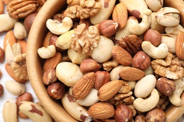 Mix of different nuts in bowl on table, top view