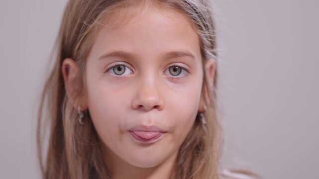 Pretty girl sticking out her tongue and teasing while looking at the camera, giving a playful expression in a close-up portrait shot