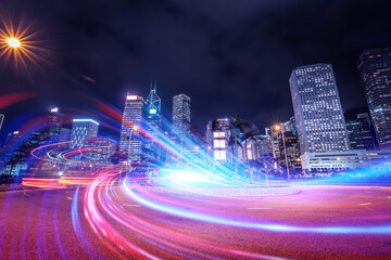 A creative night view of Hong Kong, China, showcasing vibrant light trails from vehicles weaving through towering structures under a dark sky. The modern city gleams.