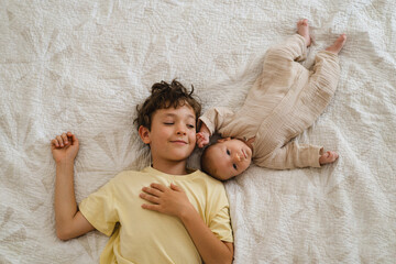 Two little boys brothers enjoying playing in cozy bright bedroom, smiling and playing. Happy childhood. Children portraits.