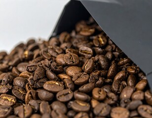 Roasted coffee beans spilling from a dark container
