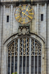 Detail of the Sao Bento Cathedral in downtown Sao Paulo, Brazil, featuring a golden clock, gothic window, and sculptures. An iconic landmark of the city's history and architecture.