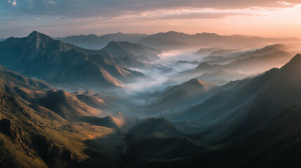 sunrise over mountain peaks, mist rolling through valleys