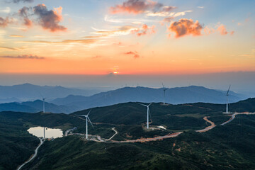 Wind power generation and windmills on a mountain at sunset.