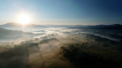 Sunrise over mountain peaks, mist rolling through valleys, cinematic landscape.