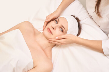 Relaxing spa treatment for young caucasian female with face massage and skincare in luxurious environment.