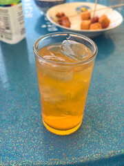 close up of a glass of water with ice and a cup of tea