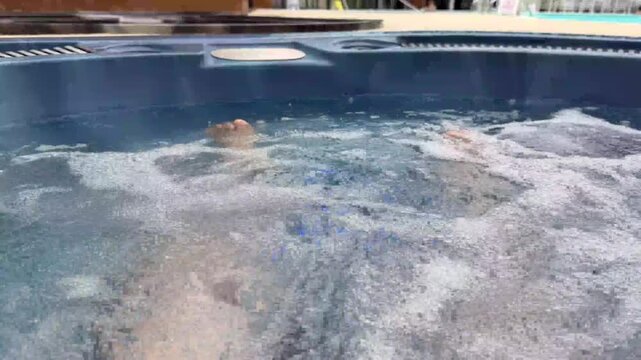 persons feet relaxing in a bubbling jacuzzi hot