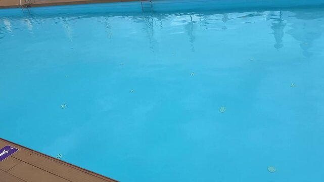 raindrops falling on an outdoor swimming pool surf