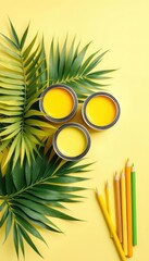 Fresh yellow paint cans, assorted pencils, and vibrant green foliage provide creative inspiration and possibilities