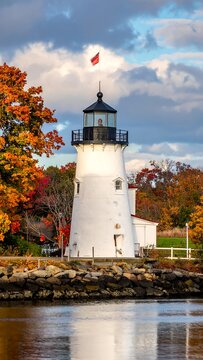 Classic lighthouse with autumn foliage at sunrise