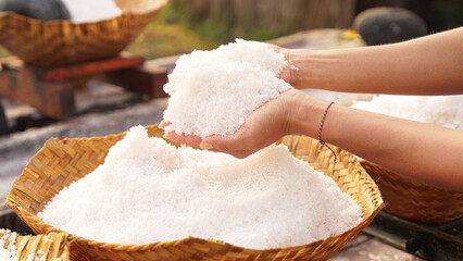 Farmer hands with natural bali sea salt, pure and coarse, hand harvested, woven bamboo basket