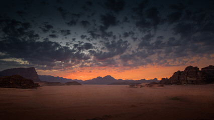 Wadi Rum desert glows beneath a dramatic red sunset sky.