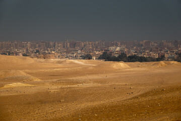 The city of Giza rises from the golden desert sands. © Tom